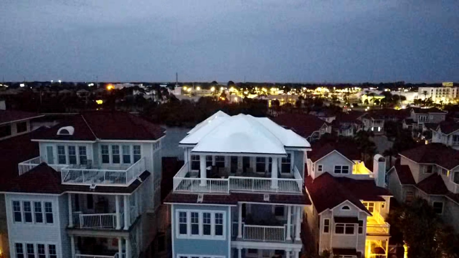 Coastal condominium and townhome buildings sealed under RoofWrap at dusk