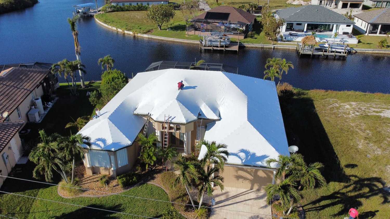 Canal-front home with a white RoofWrapped roof